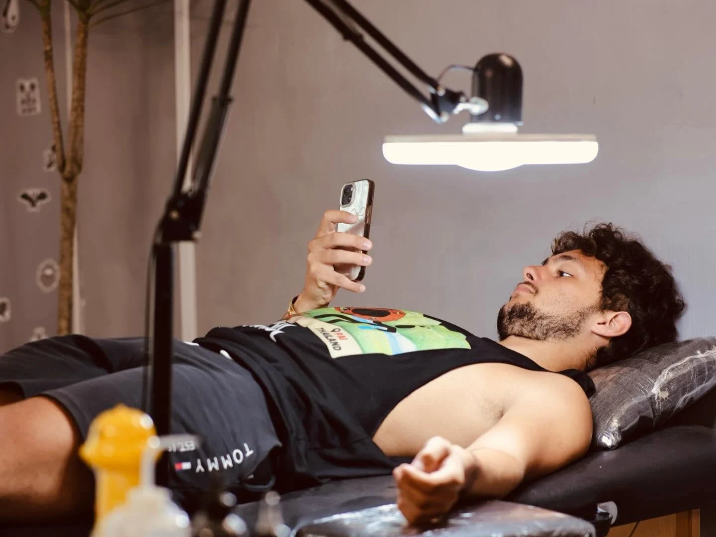 Tattoo artist creating detailed black ink work in a professional studio